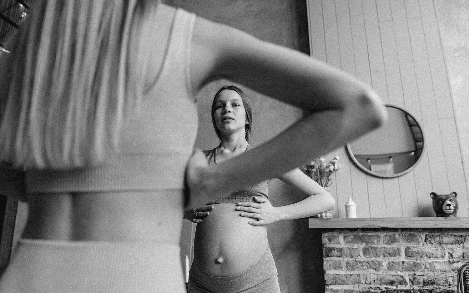Une femme enceinte pratiquant un exercice de respiration contrôlée debout avec le sophrologue