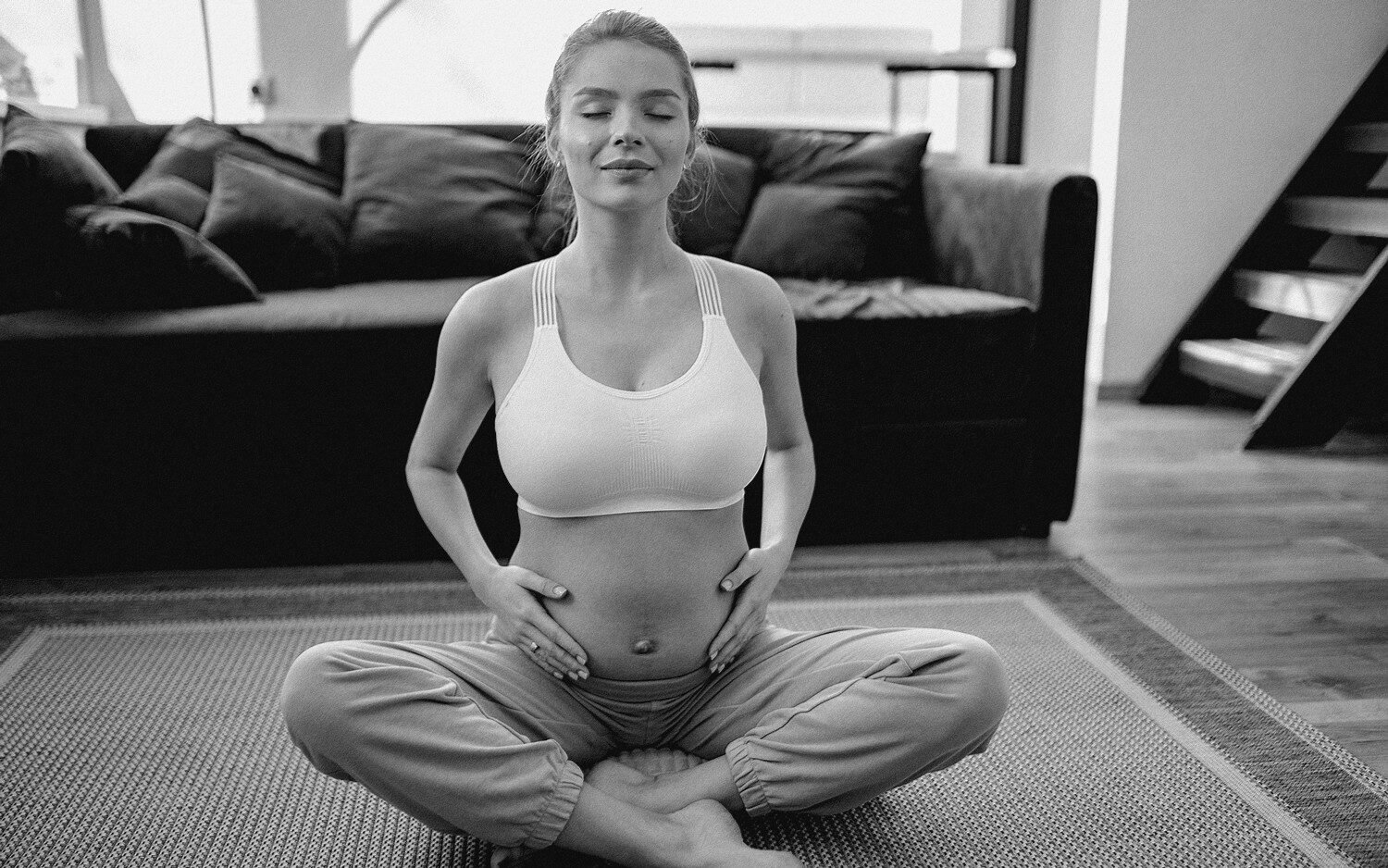 Une femme enceinte pratiquant un exercice de respiration contrôlée assise en tailleur