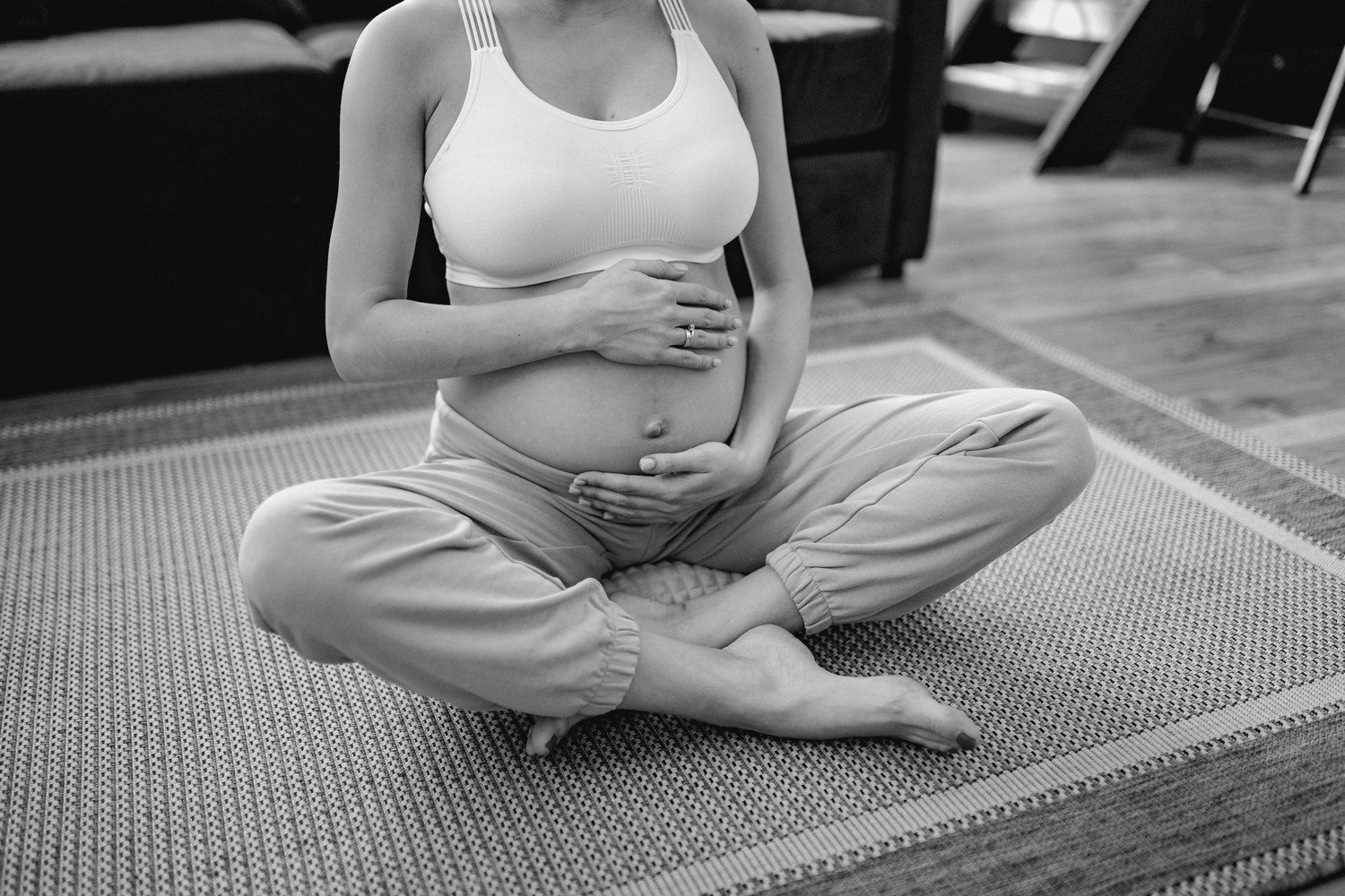 Une femme enceinte en train de pratiquer un exercice de sophrologie assise en tailleur